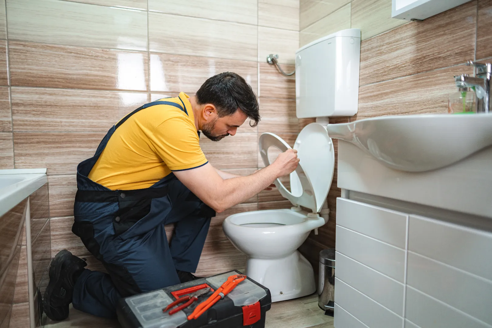 Plumber working on toilet repair in Brampton bathroom — professional licensed service