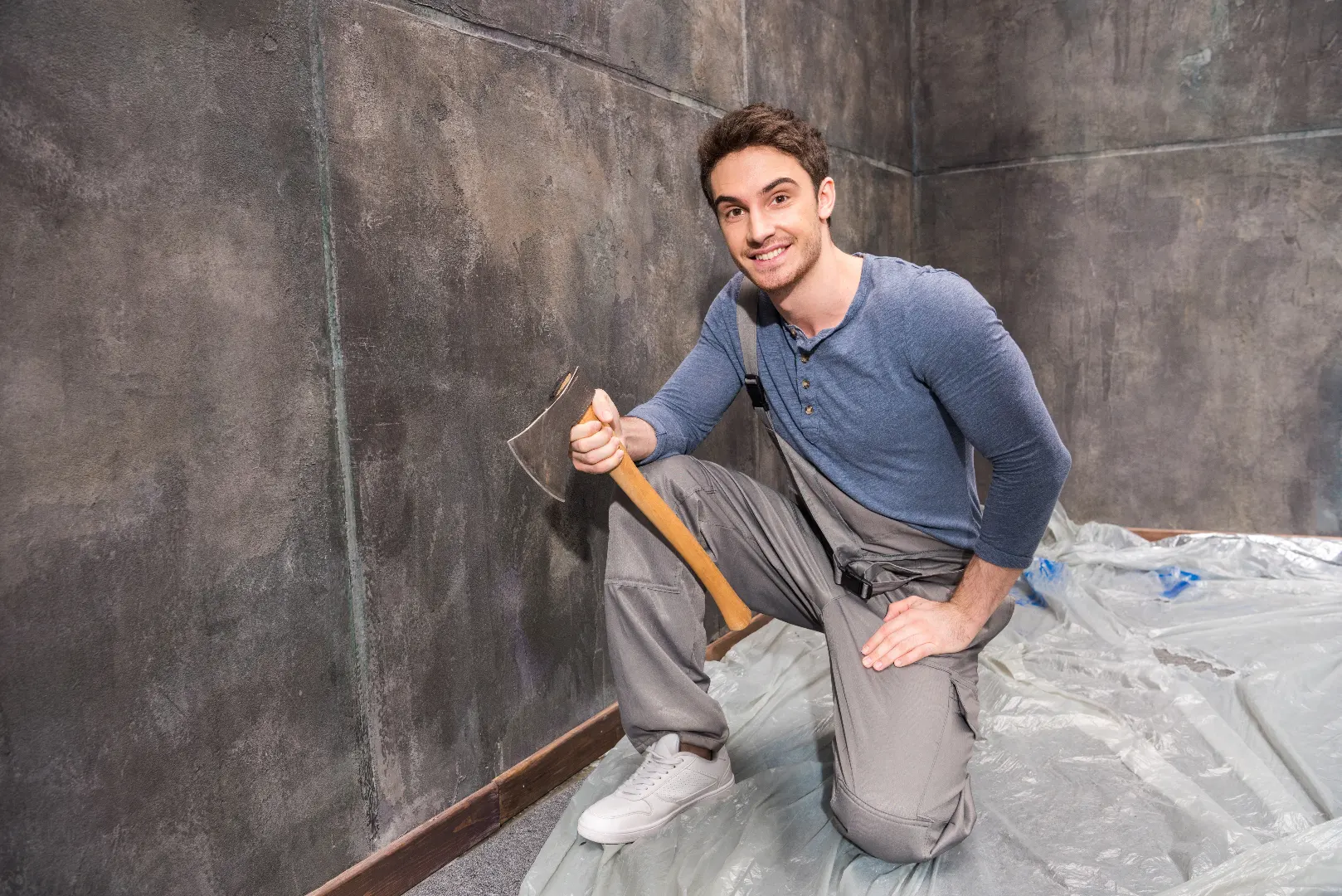 Professional handyman repairing basement floor in Caledon rural home — plumbing and renovation