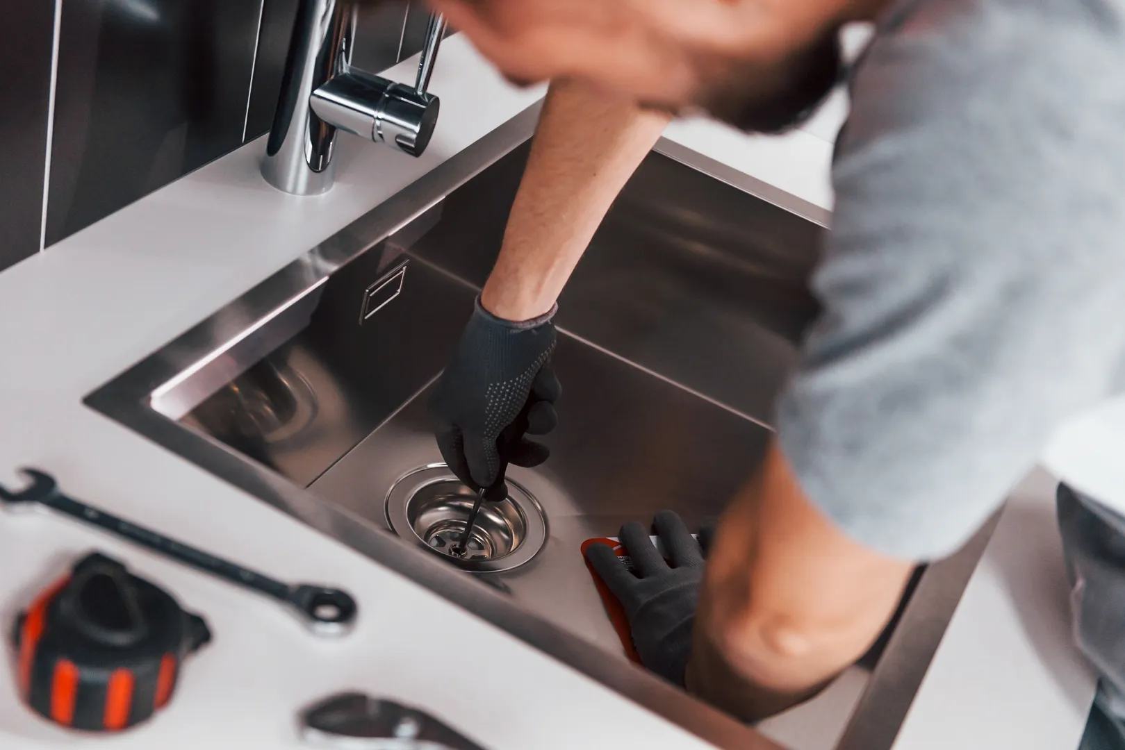 Professional drain cleaning plumber in grey uniform working across Toronto neighbourhoods