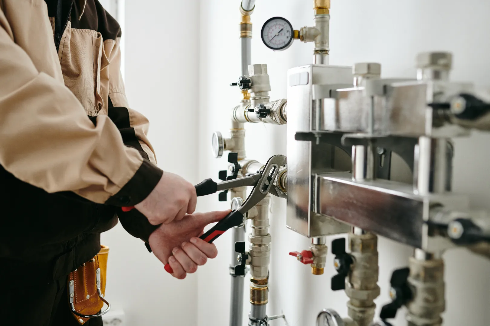 Commercial plumber in uniform using tools for repair in Vaughan — residential and commercial service