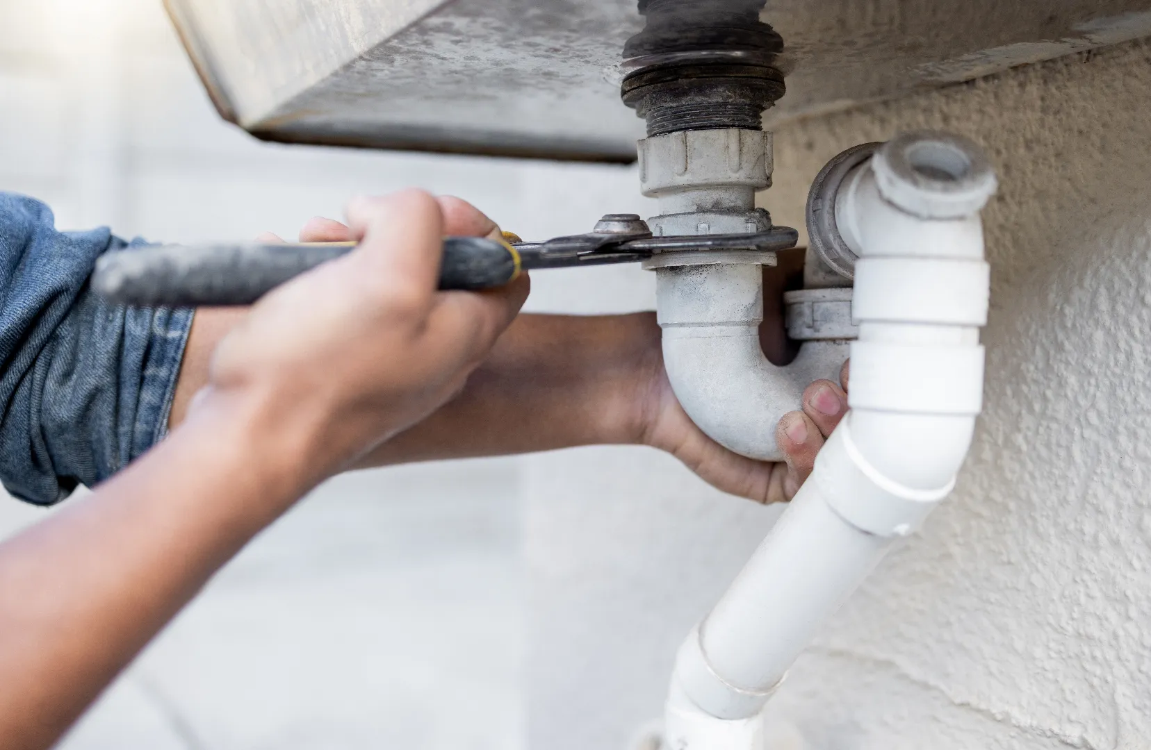 Plumber with tools fixing pipe — professional pipe repair and leak detection across Toronto GTA