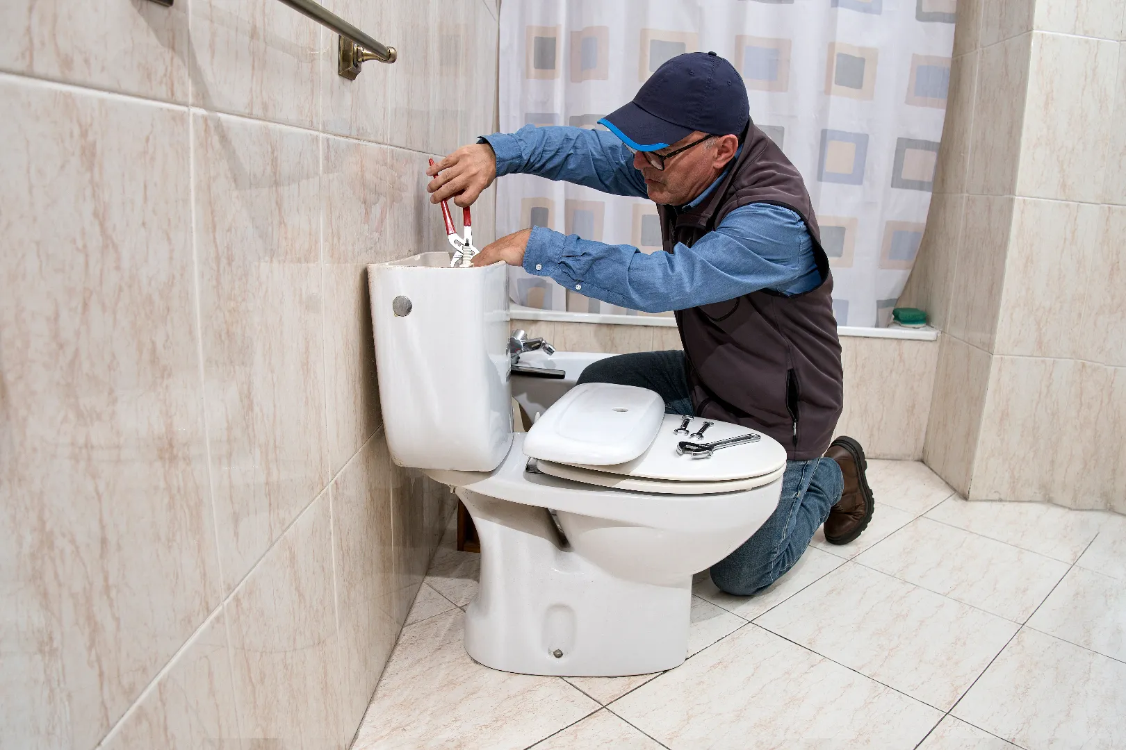 Licensed plumber repairing toilet cistern — professional toilet repair service across Toronto GTA